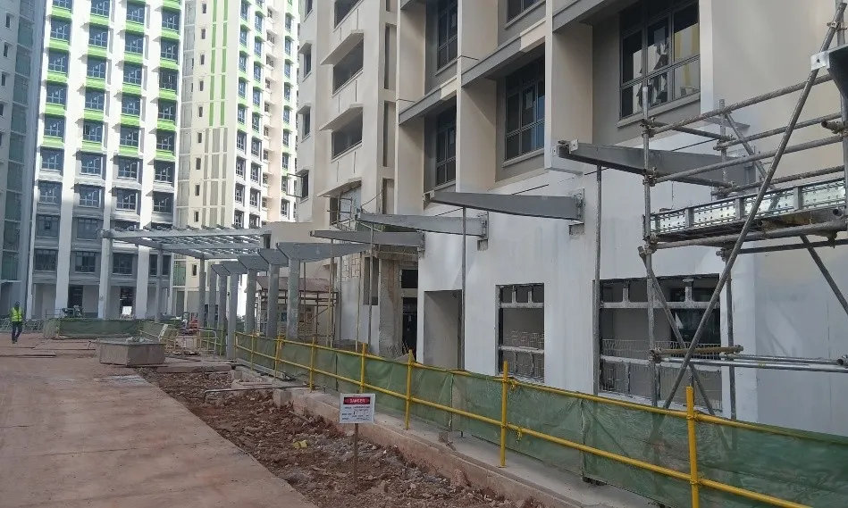 Steel linkway framing along residential blocks with scaffolding and safety barriers at Tengah PA C1 & CG.